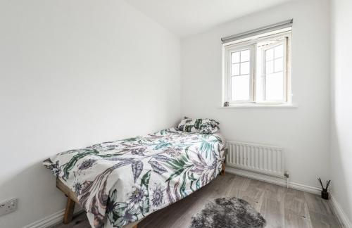 a bedroom with a bed and a window at Beautiful Comfortable House in Thamesmead
