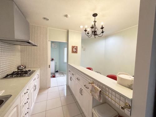 una cocina con armarios blancos y una lámpara de araña en Ocean Villa Tin Gala en Onna