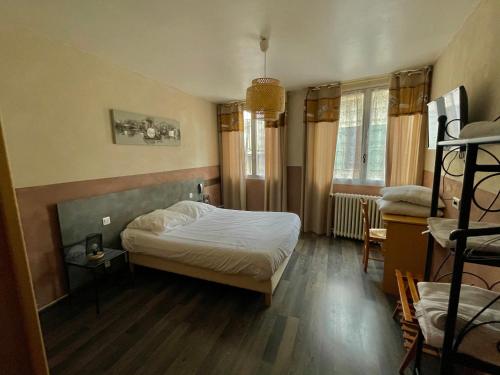 a small bedroom with a bed and two windows at Hotel François 1Er in Manosque