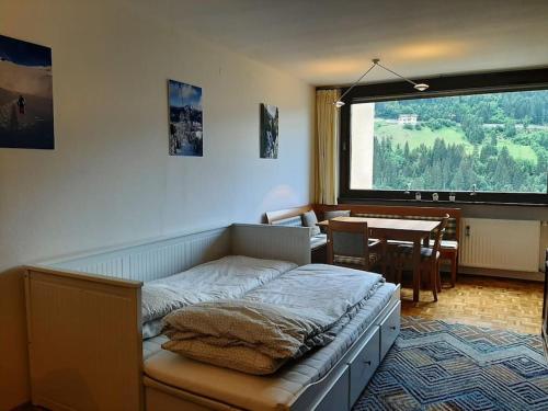 a bedroom with a bed and a dining room at Cozy apartment w a view & own garden in Bad Gastein