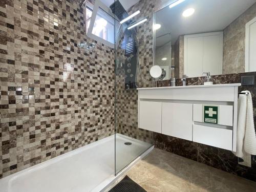 a bathroom with a tub and a sink and a mirror at Sea and Sun 4 You - Porto Moniz in Porto Moniz