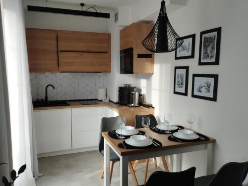 uma pequena cozinha com mesa e cadeiras num quarto em Apartament pod Świerkami em Szklarska Poręba