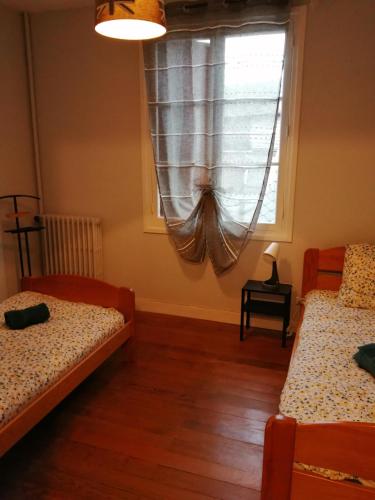 a bedroom with two beds and a window at Gîte d'EU la Rivière à la Mer in Eu