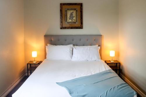 ein Schlafzimmer mit einem Bett mit zwei Lampen auf beiden Seiten in der Unterkunft Tates Hotel Windsor in Windsor