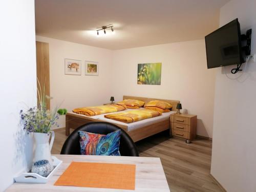 Pension Stern في Rauenberg: غرفة نوم بسرير ومكتب وطاولة