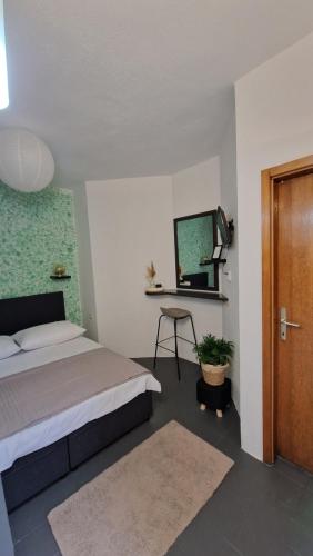 a bedroom with a bed and a table and a mirror at Studio Nina in Kastel Stafilic