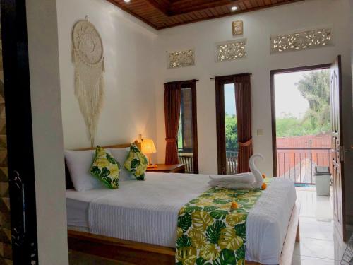 um quarto com uma cama com um cisne em Nano Ari Homestay em Ubud