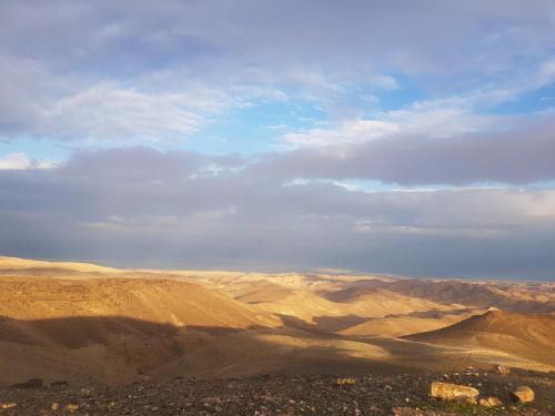 a view of a desert with mountains and a sky at Sun, Mountain & Adventure in Arad