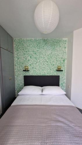 um quarto com uma cama grande e uma parede verde em Studio Nina em Kaštel Štafilić