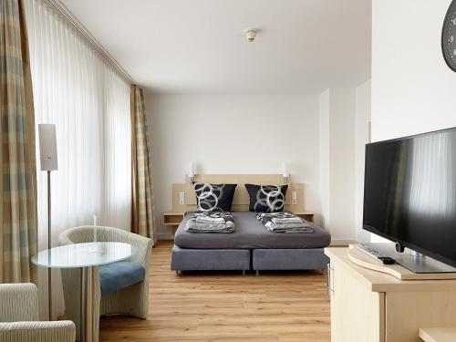 a living room with a bed and a flat screen tv at Schöne Apartments I private Parkplätze I home2share in Münster