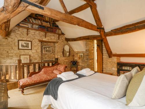 um quarto com uma cama grande numa parede de pedra em Brooklands em Chedworth