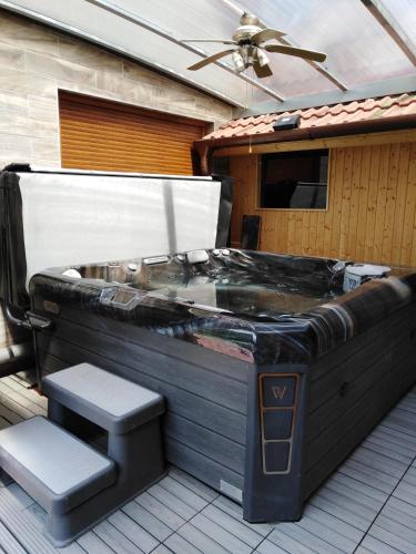 a jacuzzi tub on a deck with a ceiling at Farkas Guesthouse in Balatonszentgyörgy