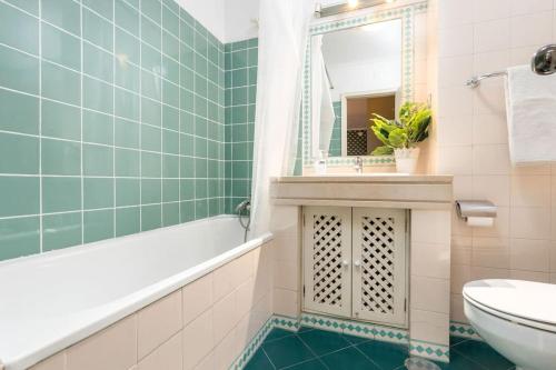 uma casa de banho com uma banheira, um WC e um lavatório. em RenFeb23Boavista Deluxe with private parking no Porto