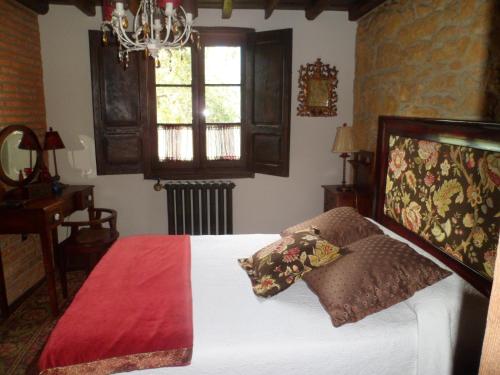 a bedroom with a bed and a chandelier at Casa Rural La Retuerta in Nava