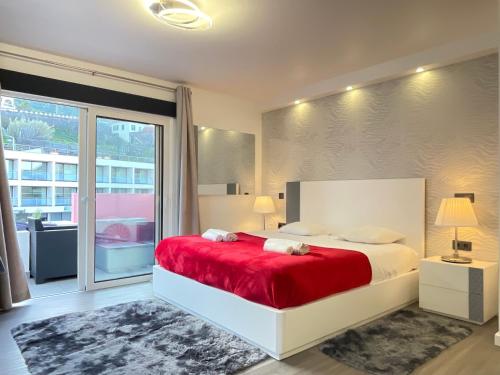 1 dormitorio con 1 cama grande con manta roja en Sea and Sun 4 You - Porto Moniz, en Porto Moniz