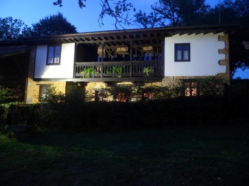 a house with a porch and a deck at night at Casa Rural La Retuerta in Nava