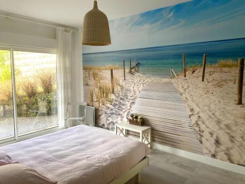ein Schlafzimmer mit einem Bett und einem Wandbild vom Strand in der Unterkunft Modern Villa High Standing Pyla sur Mer 3' from beach in Pyla-sur-Mer