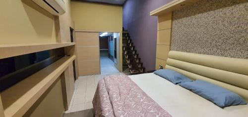 um pequeno quarto com uma cama e uma escada em Luxury & Complete 3 Bedroom Penthouse em Shah Alam