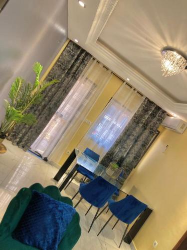 a living room with a table and chairs and a window at At Home Lisda in Yaoundé