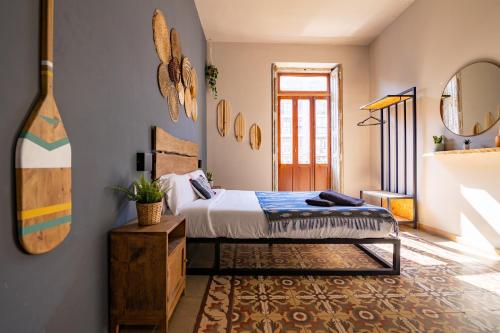 een slaapkamer met een bed en een spiegel bij Bird House in Valencia
