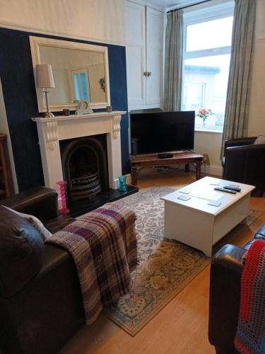 a living room with a couch and a fireplace at Dales View House in Barnoldswick