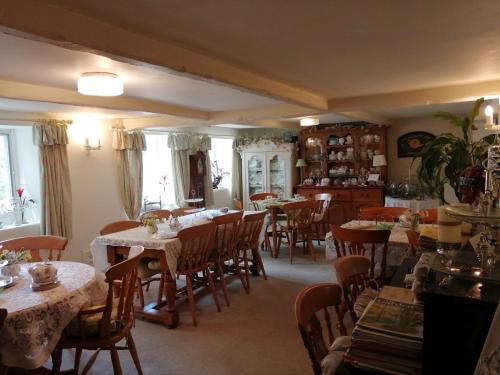 a dining room with tables and chairs and windows at The Willows in Shillingstone