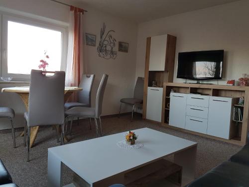 ein Wohnzimmer mit einem Tisch und einem TV in der Unterkunft Feriendomizil Elbsandsteingebirge in Königstein an der Elbe