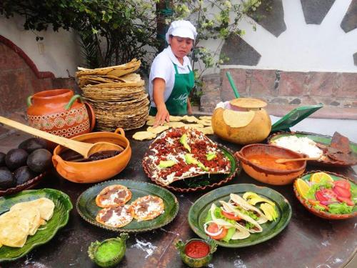 Casa Rustica en la Reserva Tehuacán-Cuicatlán : امرأة تقف أمام طاولة مع أطباق من الطعام