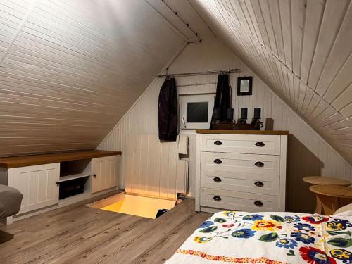 a attic bedroom with a bed and a dresser at Chatka pod Martinskými Hoľami in Martin
