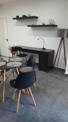 Zimmer mit Tischen und Stühlen sowie einem Schreibtisch in der Unterkunft Glyfada Vacation Apt in Athen