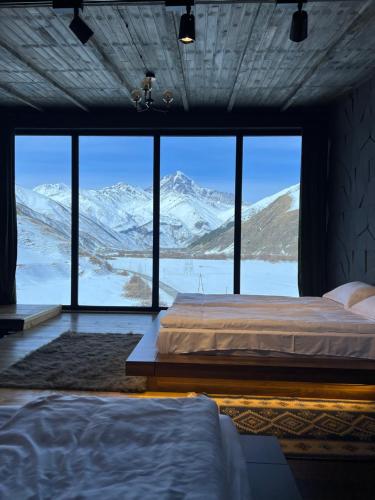 a bedroom with a bed with a view of mountains at Gzaze in Stepantsminda