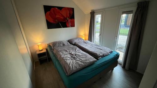 Cama pequeña en habitación con ventana en Ferienhaus tinydroom im Europarcs Bad Hoophuizen am Veluwemeer en Hulshorst
