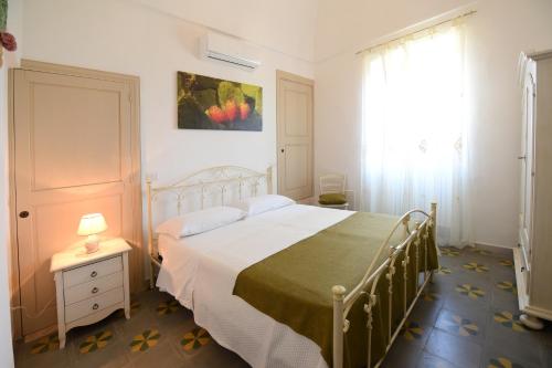 a bedroom with a white bed and a window at Masseria Peppeturro in Cisternino