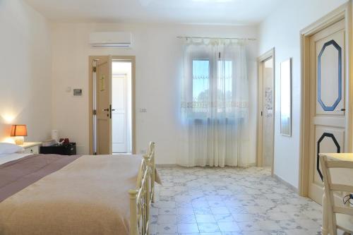 a bedroom with a bed and a door with a window at Masseria Peppeturro in Cisternino