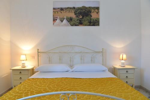a bedroom with a large bed with two night stands at Masseria Peppeturro in Cisternino