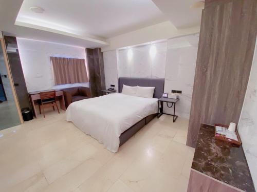 a bedroom with a large white bed and a table at Michelle hotel in Yuanlin