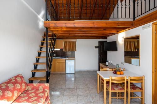 a living room with a staircase and a table and chairs at Sunday Hotel in Ialyssos