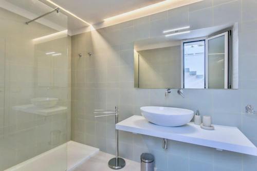 a bathroom with a sink and a mirror and a shower at Domus Maulli - Villa sul mare in Marina di Ragusa