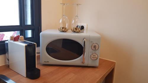 a microwave with two wine glasses on top of it at Sun, Mountain & Adventure in Arad