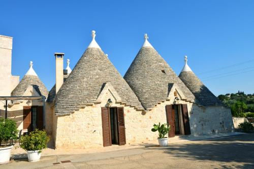 an old brick building with a roof with turrets at Masseria Peppeturro in Cisternino