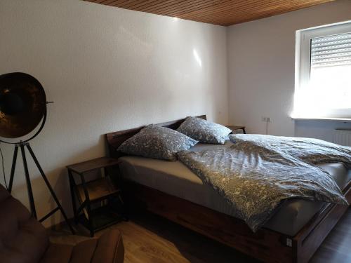1 dormitorio con cama con almohadas y ventana en Hochgratstrasse, en Oberreute