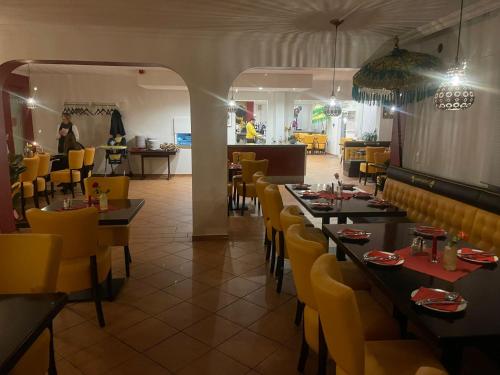ザンクト・イングベルトにあるHotel Am Wildparkのレストランのダイニングルーム(テーブル、黄色い椅子付)