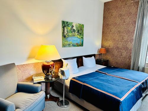 Habitación de hotel con cama y sofá en ZU DEN LINDEN - RADEBEUL Pension mit Restaurant, en Radebeul