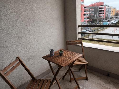 a wooden table and two chairs on a balcony at Odmor u Zagrebu in Zagreb