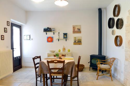 a dining room with a table and chairs and a fireplace at Masseria Peppeturro in Cisternino