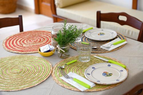 a table with plates and napkins on top of it at Masseria Peppeturro in Cisternino