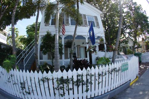 a white picket fence in front of a white house at Seascape Tropical Inn in Key West