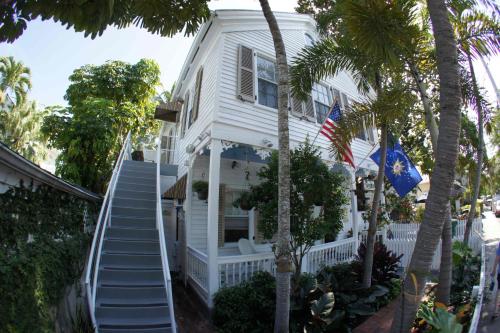 a white house with stairs leading up to it at Seascape Tropical Inn in Key West