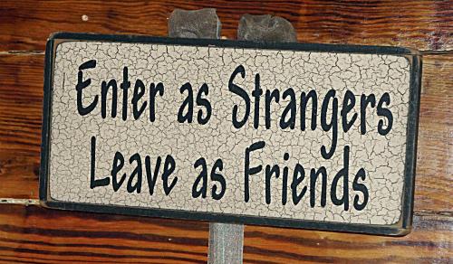 a sign that saysenter as strangers leave as friends at Seascape Tropical Inn in Key West