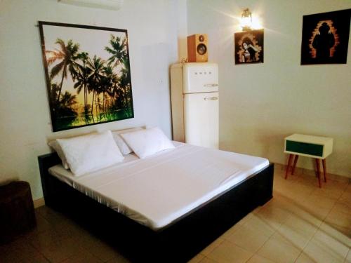a bedroom with a large bed with a refrigerator at La CASA in Ouagadougou